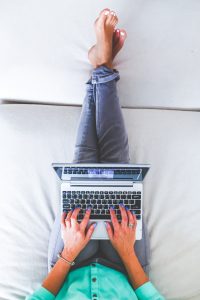 אישה מקלידה על המחשב במיטה